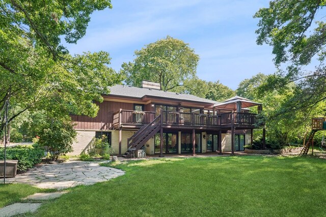 rear view of house featuring a deck, a patio, and a yard