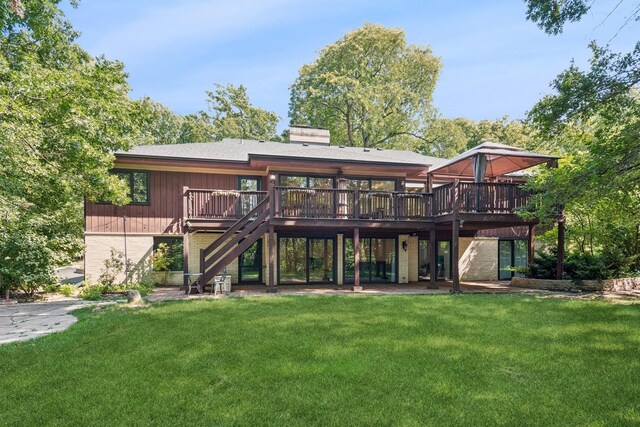 back of house featuring a lawn and a wooden deck