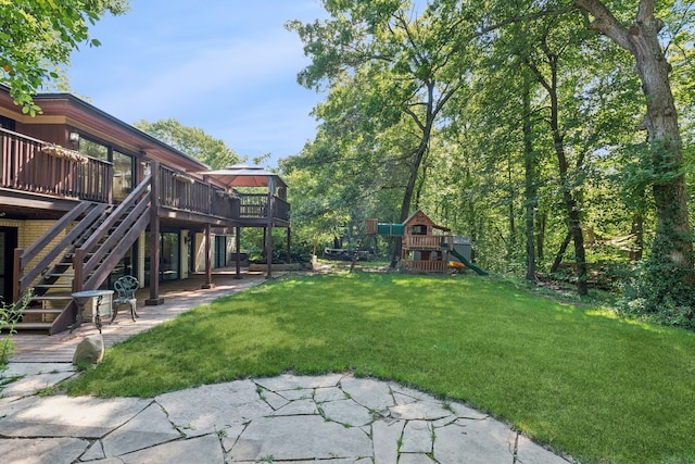 view of yard with a patio area, a playground, and a deck