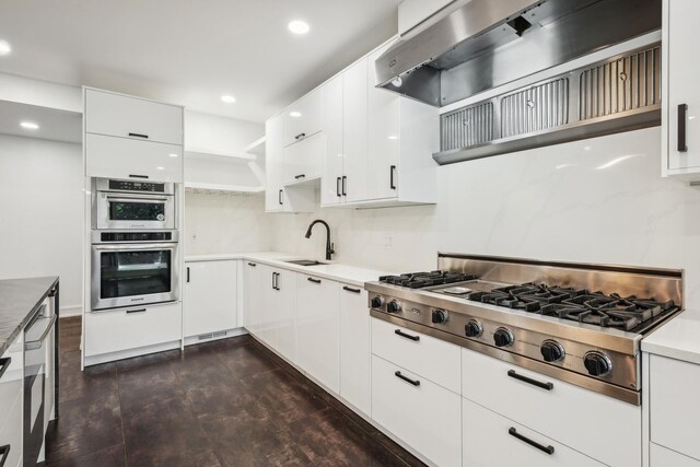 kitchen featuring white cabinets, stainless steel appliances, sink, and wall chimney range hood