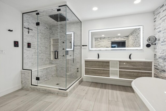 bathroom with independent shower and bath and double sink vanity