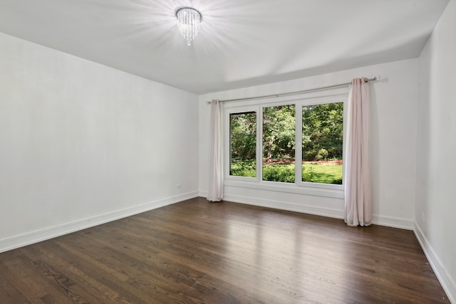 unfurnished room with dark hardwood / wood-style flooring