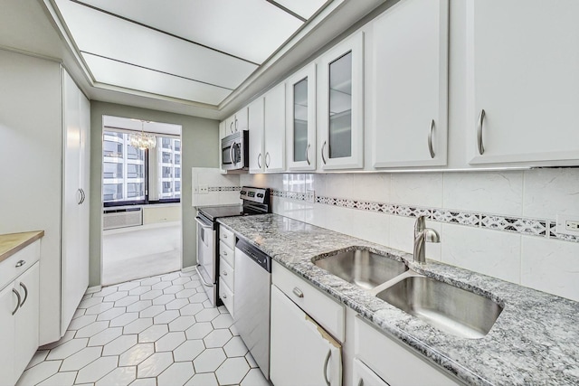 155 N Harbor Dr Unit 1003, Chicago, IL 60601 - kitchen featuring glass insert cabinets, white cabinetry, a sink, appliances with stainless steel finishes, and a notable chandelier