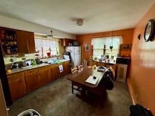 kitchen with white refrigerator and dark tile patterned flooring