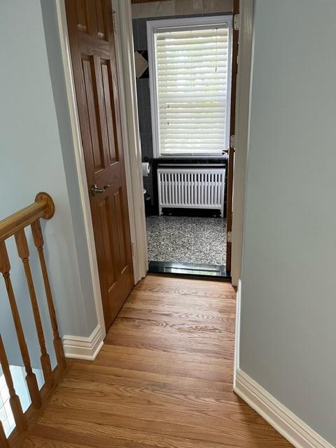 corridor featuring light hardwood / wood-style floors and radiator