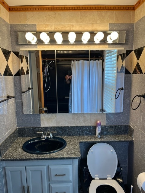 bathroom with vanity, tile walls, tasteful backsplash, and toilet