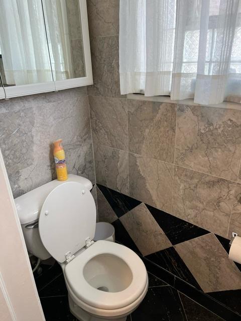 bathroom featuring tile walls and toilet