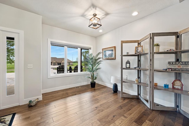 interior space featuring recessed lighting, wood-type flooring, visible vents, a textured ceiling, and baseboards