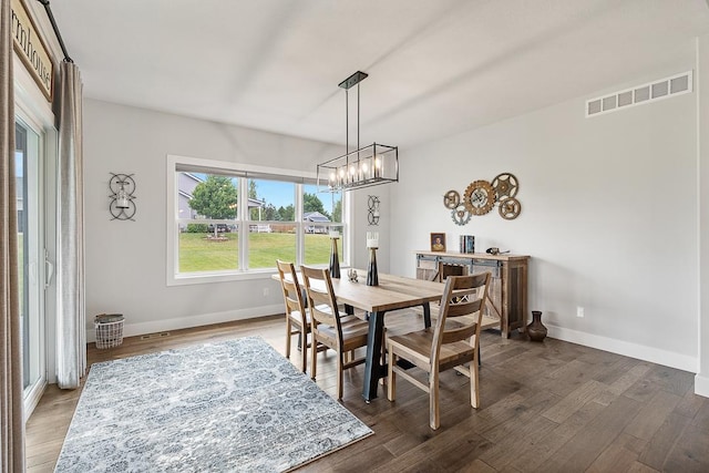 dining area with an inviting chandelier, wood finished floors, visible vents, and baseboards