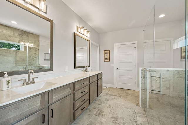 bathroom with double vanity, a stall shower, and a sink