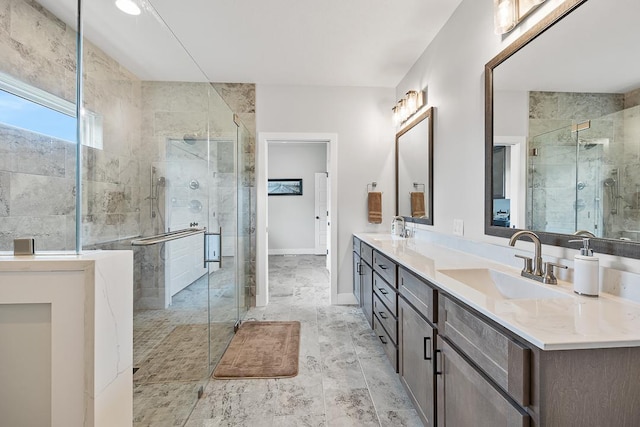 bathroom with baseboards, double vanity, a sink, and a shower stall