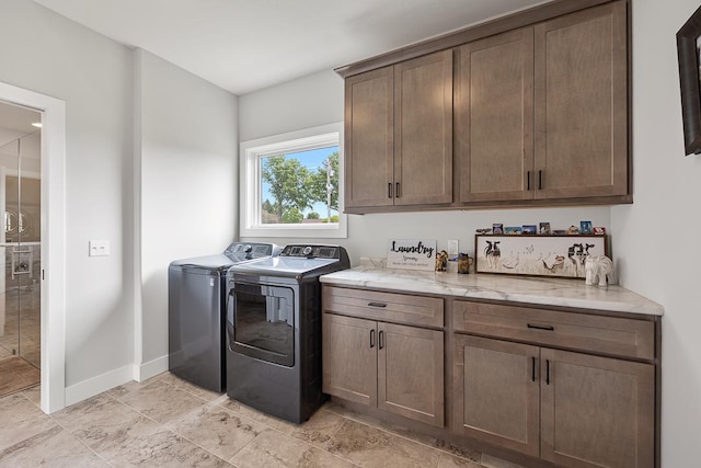 laundry area with cabinet space, independent washer and dryer, and baseboards