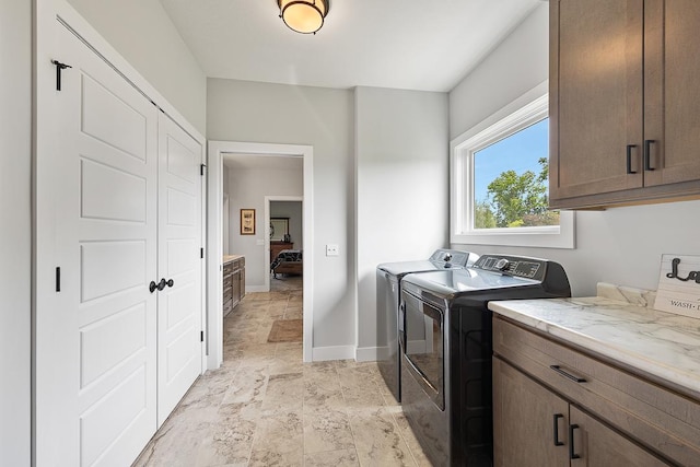 laundry room featuring baseboards, cabinet space, and washer and dryer