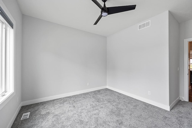 unfurnished room featuring carpet, visible vents, and baseboards