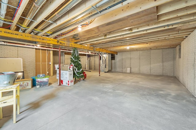 unfinished basement with brick wall and heating unit