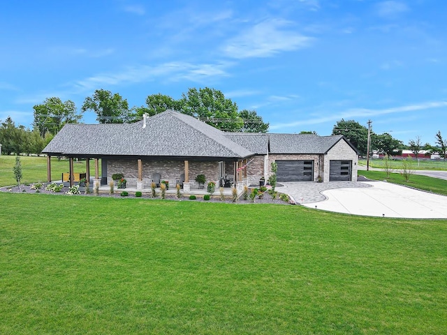 view of front of house with a front yard, concrete driveway, roof with shingles, and an attached garage