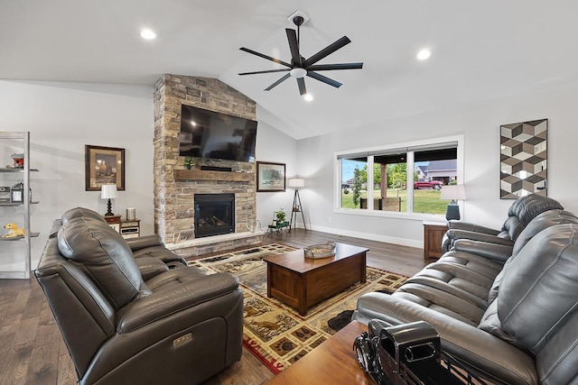 living room featuring baseboards, vaulted ceiling, wood finished floors, and a stone fireplace