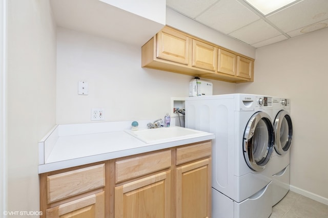 washroom with cabinets, washing machine and dryer, sink, and light tile patterned floors