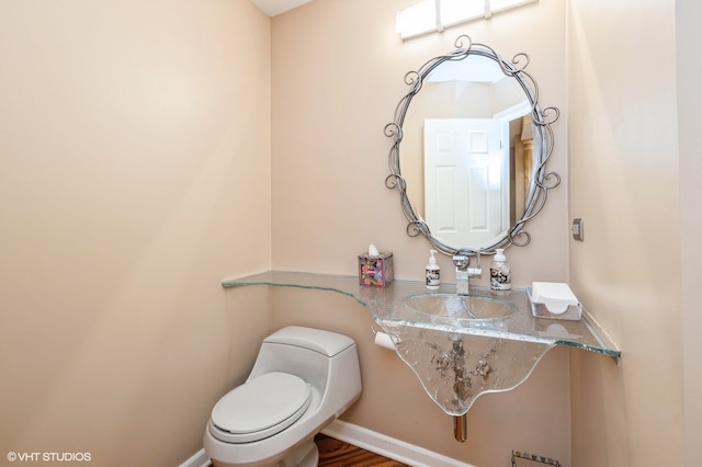 bathroom featuring sink, toilet, and hardwood / wood-style flooring