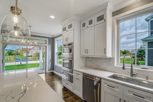 kitchen with white cabinetry, tasteful backsplash, dark wood-type flooring, appliances with stainless steel finishes, and decorative light fixtures