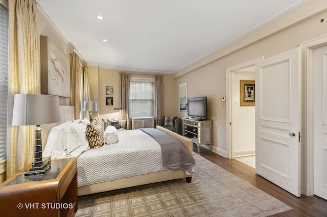 bedroom with crown molding and hardwood / wood-style flooring