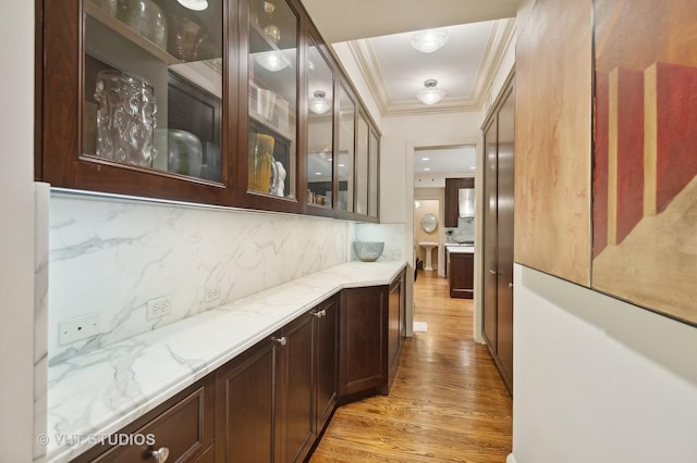 hall with ornamental molding and light hardwood / wood-style flooring