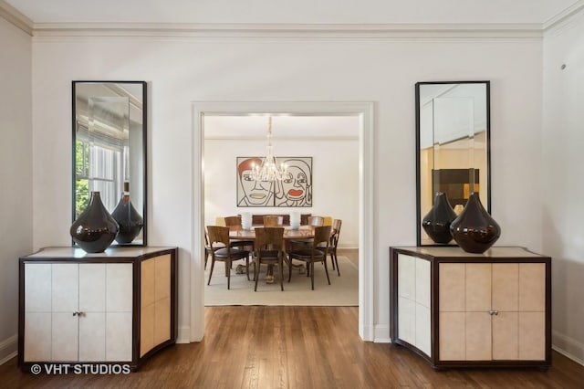 dining area featuring dark wood-type flooring, a chandelier, and ornamental molding