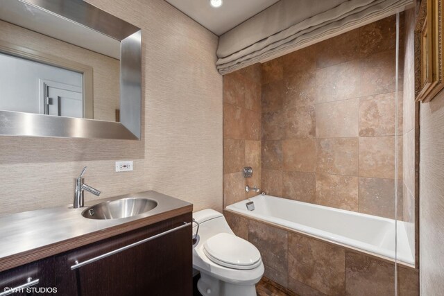 full bathroom featuring vanity, toilet, and tiled shower / bath combo