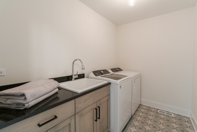 laundry area featuring cabinets, independent washer and dryer, sink, and light tile patterned floors