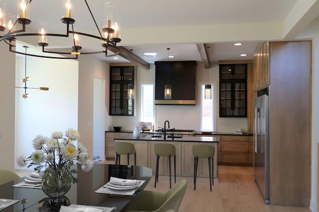 kitchen with a chandelier, beamed ceiling, light hardwood / wood-style floors, hanging light fixtures, and high end refrigerator