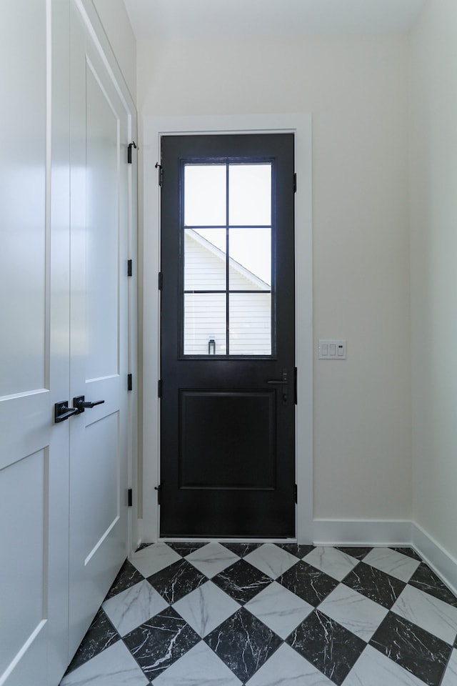 doorway to outside featuring dark tile patterned flooring