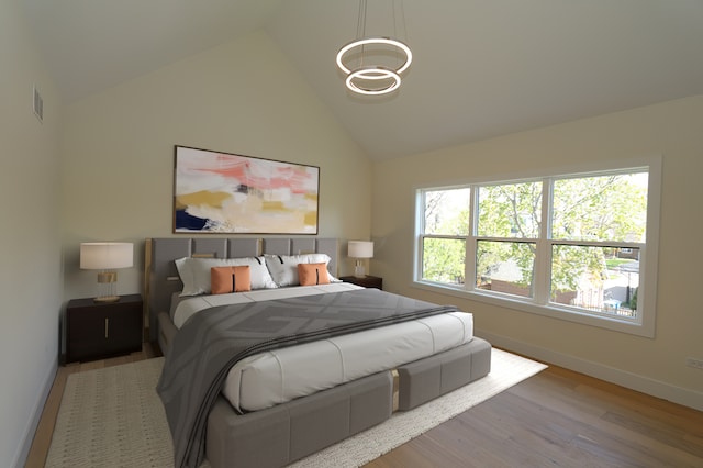 bedroom featuring hardwood / wood-style floors and high vaulted ceiling