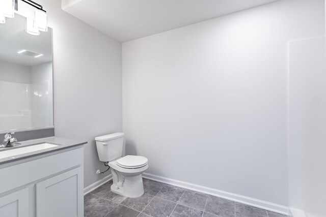 bathroom with tile flooring, vanity, and toilet