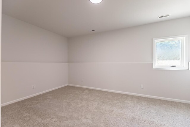 spare room featuring vaulted ceiling and carpet floors