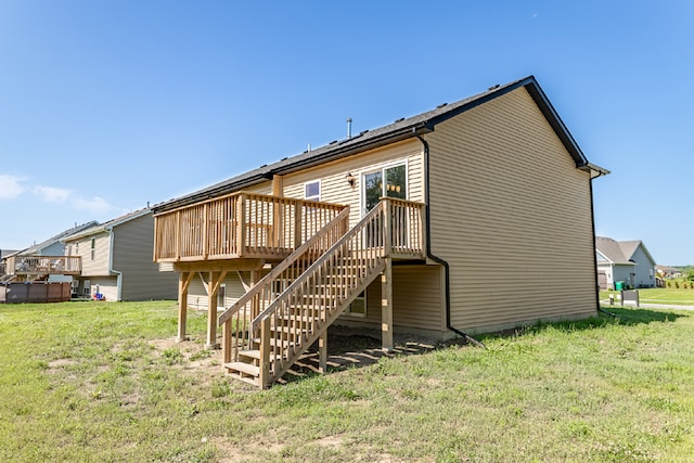 rear view of property featuring a deck and a yard