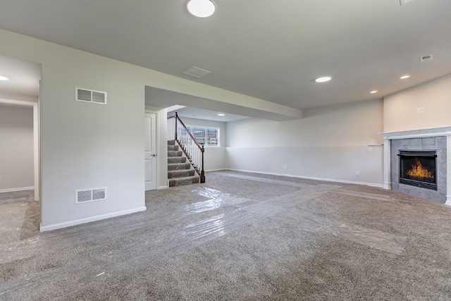 unfurnished living room with stairway, a fireplace, carpet flooring, and visible vents