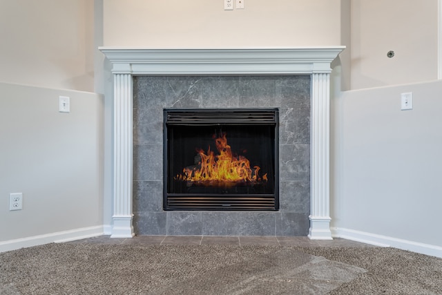 room details with baseboards, carpet flooring, and a tiled fireplace