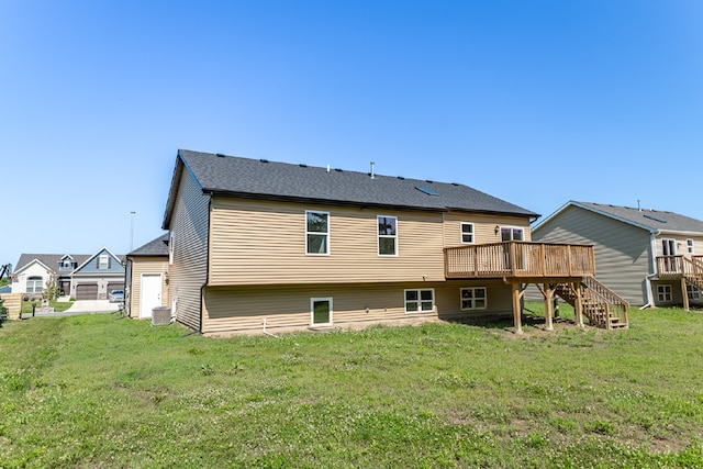 rear view of property featuring a yard, a deck, and central AC unit