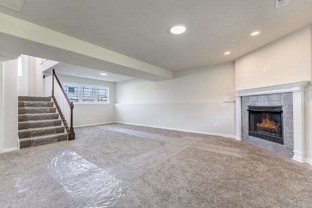 unfurnished living room with carpet and a tile fireplace