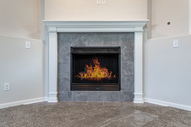 room details featuring a tile fireplace and carpet floors