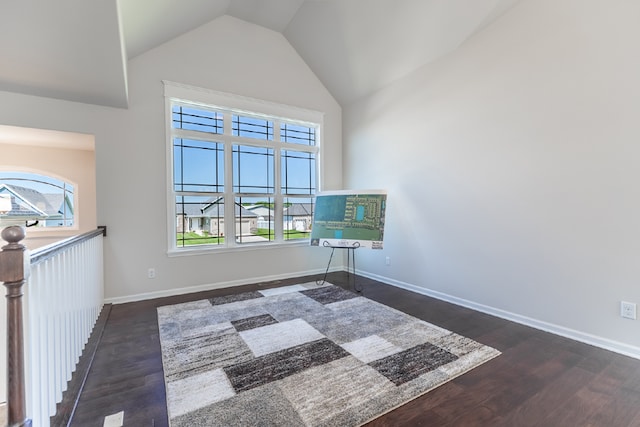 spare room with high vaulted ceiling, baseboards, a wealth of natural light, and wood finished floors