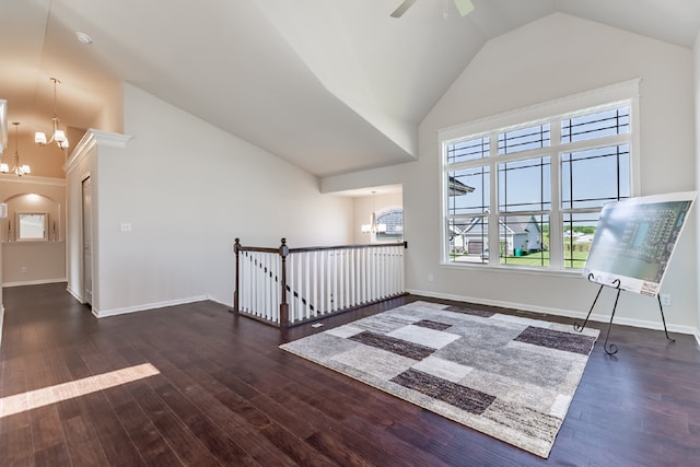 interior space featuring baseboards, high vaulted ceiling, and wood finished floors