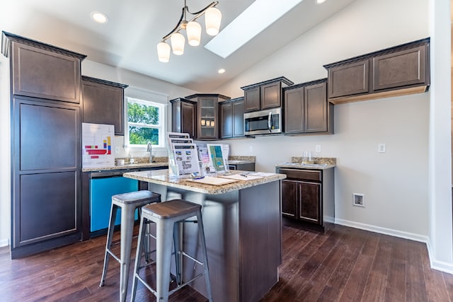 kitchen with dishwashing machine, a kitchen island, stainless steel microwave, and dark brown cabinets