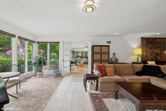 living room with a textured ceiling and french doors