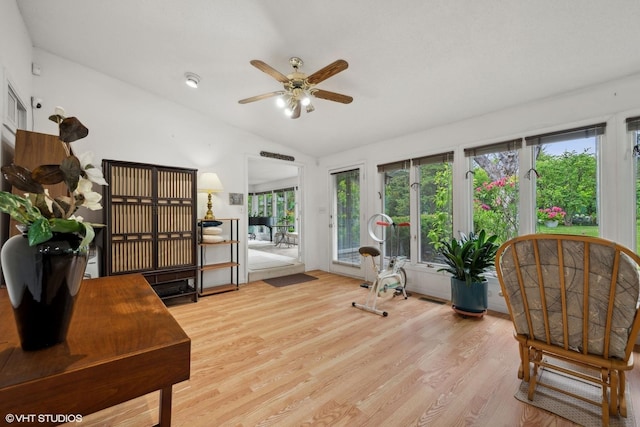 living area with vaulted ceiling, ceiling fan, and light wood-type flooring