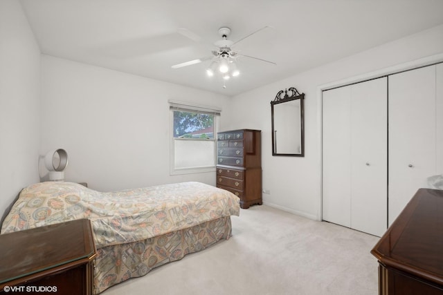 bedroom featuring light carpet, ceiling fan, and a closet