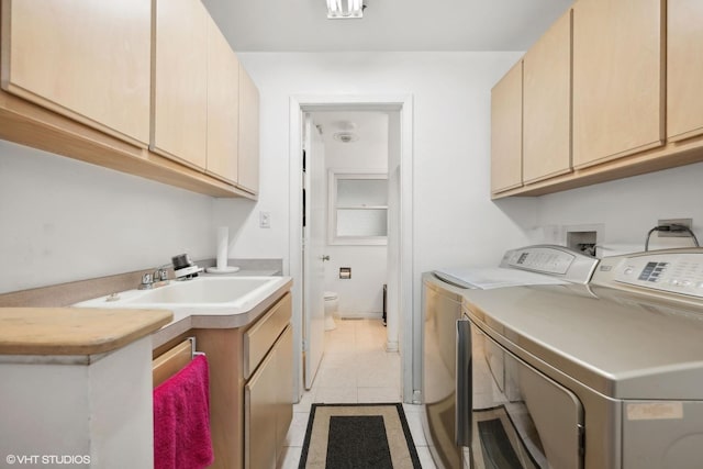 laundry area with cabinets, sink, washing machine and dryer, and light tile patterned floors