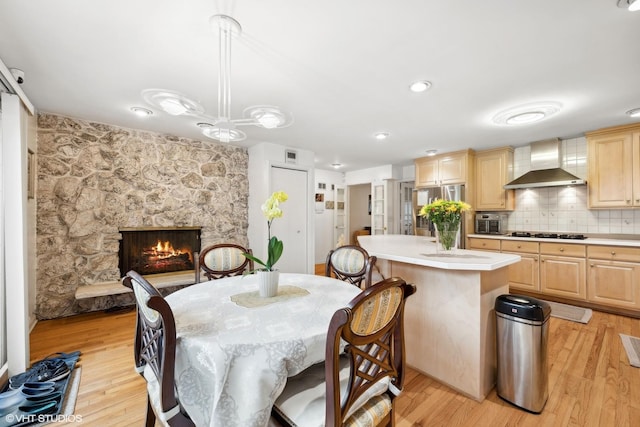 dining room featuring a fireplace and light hardwood / wood-style flooring