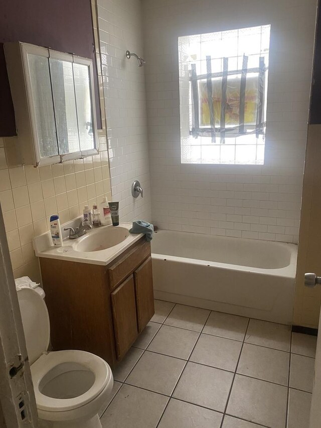 full bathroom featuring tasteful backsplash, toilet, tiled shower / bath combo, vanity, and tile walls