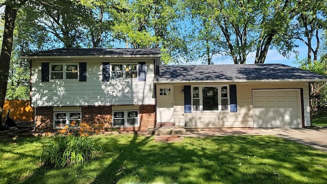 split level home featuring a garage and a front lawn